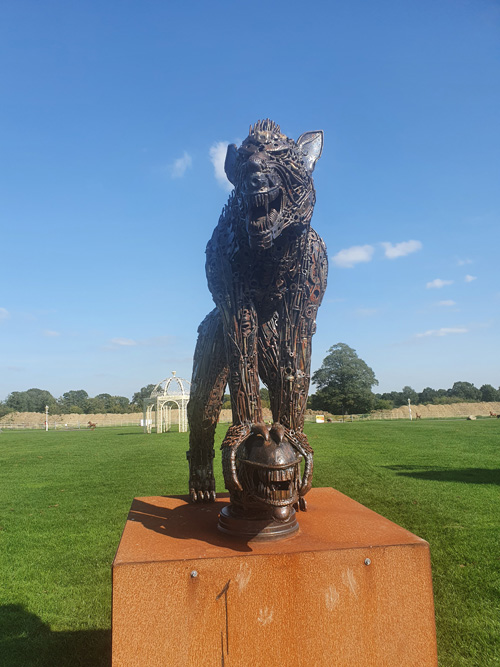 A striking metal sculpture of a werewolf at the British Ironwork Centre, showcasing the creature in a dynamic, menacing pose with detailed features and a fierce expression