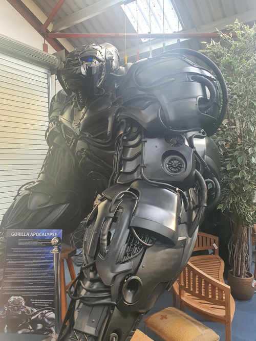 A detailed metal sculpture of a mechanical gorilla at the British Ironwork Centre, featuring intricate gears and components that form its powerful, lifelike pose.