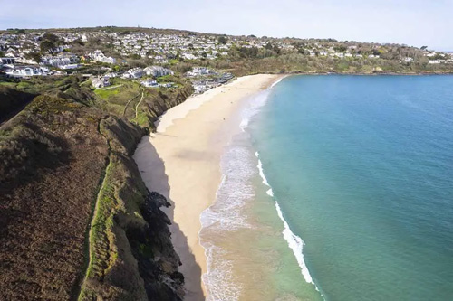 A captivating photo of Carbis Bay, showcasing its pristine sandy beach and crystal-clear waters. The image highlights the serene beauty and tranquil atmosphere of this popular coastal destination in Cornwall. Ideal for beach lovers, travelers, and anyone interested in scenic coastal landscapes