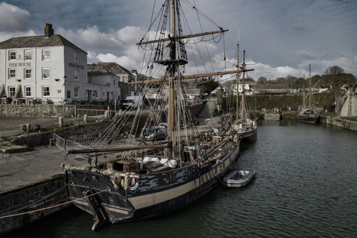 Experience the charming view of Charlestown Harbour in Cornwall. Admire the historic harbor's classic Georgian architecture, traditional tall ships, and picturesque coastal scenery that define this beautiful maritime landmark