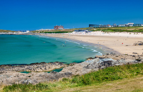 Take in the breathtaking view of Newquay Beach in Cornwall, featuring golden sands, rolling waves, and dramatic coastal cliffs. Perfect for enjoying a classic seaside landscape and vibrant beach atmosphere.