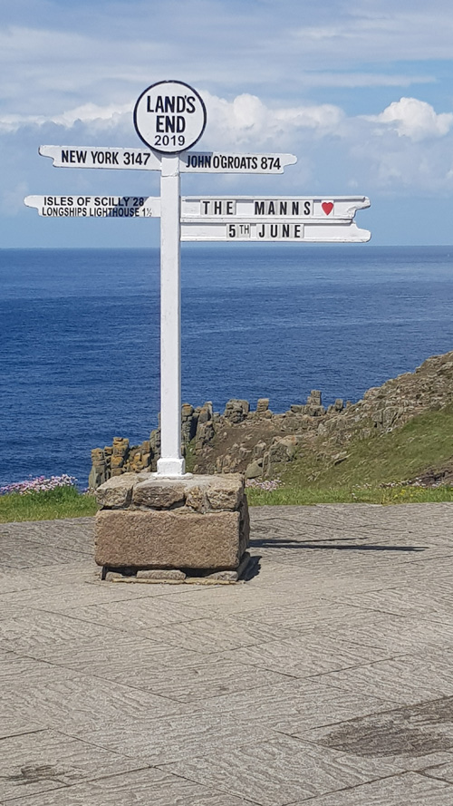 Enjoy the iconic view from Land's End with the direction post. Capture the stunning coastal scenery and the historic sign pointing to various destinations from the westernmost point of Cornwall.