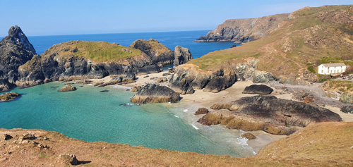Explore Poldark Strand at Kynance Cove in Cornwall, a breathtaking coastal location with golden sands, clear waters, and stunning rock formations, ideal for picturesque walks and relaxation