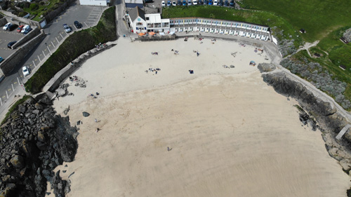 Experience a breathtaking aerial view of St Ives beach in Cornwall, showcasing the stunning golden sands, turquoise waters, and picturesque coastal scenery. Perfect for appreciating the beauty of this popular destination from above.