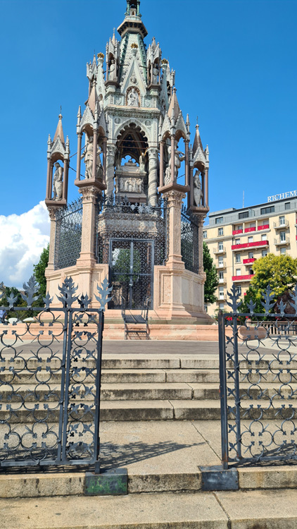 Brunswick Monument with ornate building and gate, surrounded by trees and clear sky