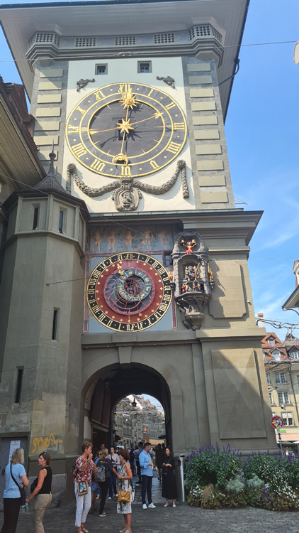 Zytglogge Clock Tower with a large clock, surrounded by people against a backdrop of the sky