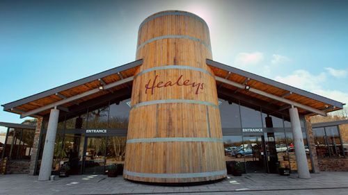 Discover the charming entrance of Healeys Cornish Cyder Farm in Cornwall. Experience a welcoming atmosphere, beautiful surroundings, and a glimpse into the world of traditional cider-making.