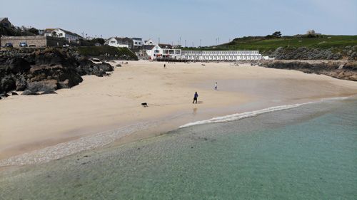 Experience a breathtaking aerial view of St Ives beach in Cornwall, showcasing the stunning golden sands, turquoise waters, and picturesque coastal scenery. Perfect for appreciating the beauty of this popular destination from above.