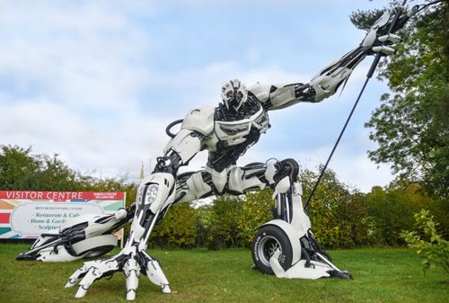 A detailed metal sculpture of a Transformer at the British Ironwork Centre, showcasing the iconic robot in a dynamic, intricate pose with visible gears and mechanical details.
