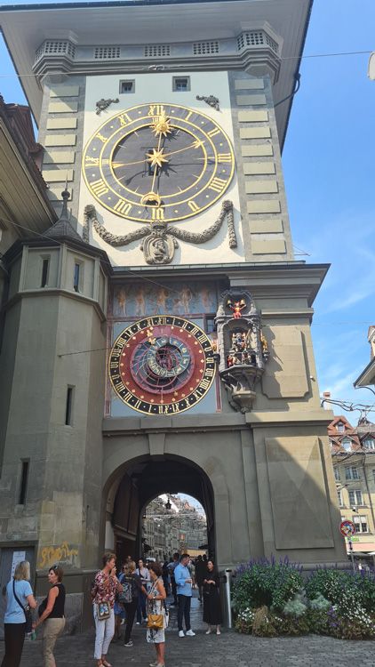 Zytglogge Clock Tower with a large clock, surrounded by people against a backdrop of the sky