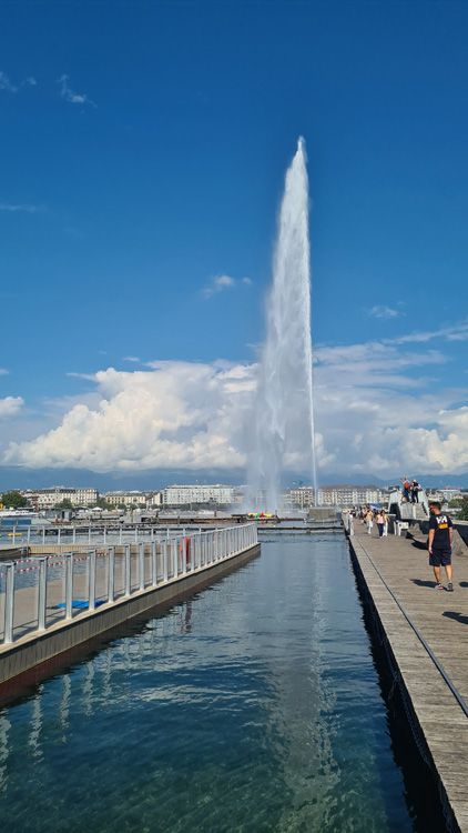 Rocket launching into the sky with dramatic clouds and Geneva Water Jet in the foreground