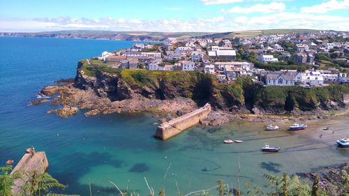 Enjoy breathtaking views over the bay in Port Isaac, a picturesque Cornish village. Admire the stunning coastal scenery, historic harbor, and charming village nestled against the rugged cliffs.