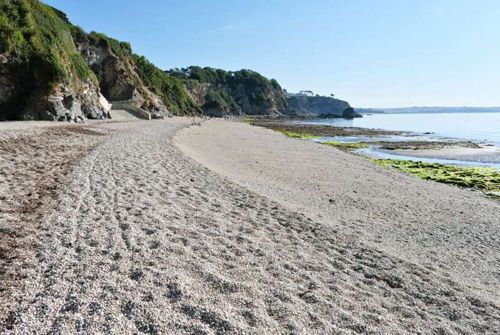 Discover the stunning view of Duporth Beach in Cornwall. Enjoy the secluded sandy shores, clear waters, and picturesque coastal cliffs that create a tranquil and scenic escape in this beautiful beach destination