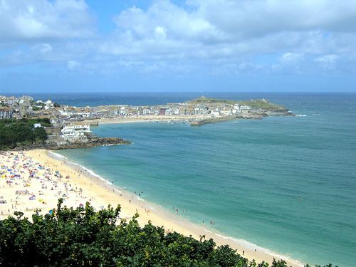 A breathtaking photo showcasing the panoramic view from the cliffs of St Ives. The image highlights the dramatic coastal landscape, with sweeping views of the turquoise waters and rugged cliff edges. Ideal for enthusiasts of nature, travel, and scenic vistas