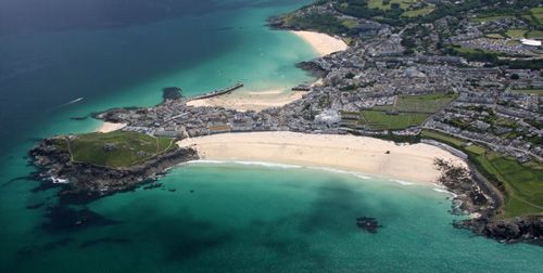 A breathtaking photo showcasing the panoramic view from the cliffs of St Ives. The image highlights the dramatic coastal landscape, with sweeping views of the turquoise waters and rugged cliff edges. Ideal for enthusiasts of nature, travel, and scenic vistas