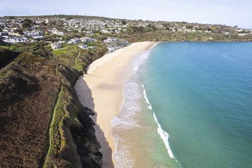 A captivating photo of Carbis Bay, showcasing its pristine sandy beach and crystal-clear waters. The image highlights the serene beauty and tranquil atmosphere of this popular coastal destination in Cornwall. Ideal for beach lovers, travelers, and anyone interested in scenic coastal landscapes