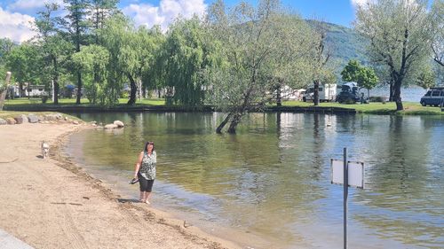 woman walking along a sandy beach next to a lake Maggiore
