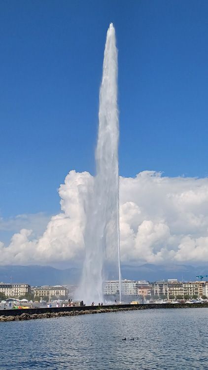 Rocket launching into the sky with dramatic clouds and Geneva Water Jet in the foreground