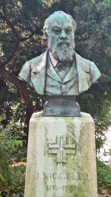 Outdoor statue by J. Nicgeler, reference number 816-188, surrounded by trees in a cemetery memorial setting